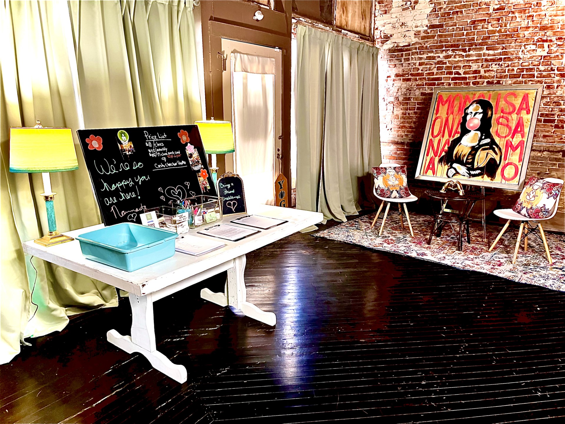 Welcome desk inside Yoga on Main with exposed brick and warm lamps